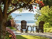 Two outdoor chairs overlooking water and mountains