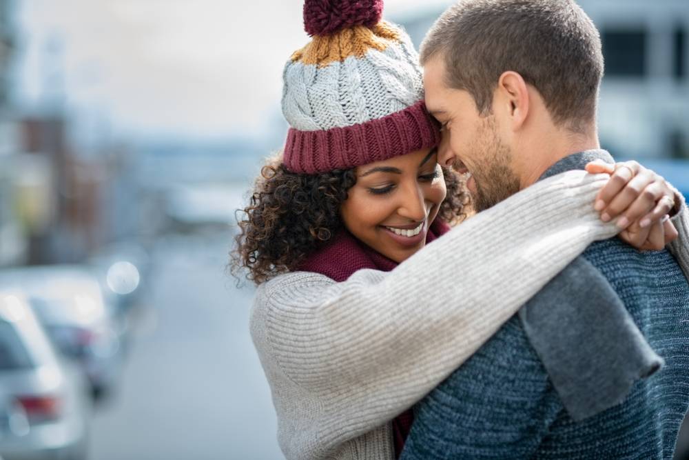 A multiracial couple embracing during their romantic getaways in New England